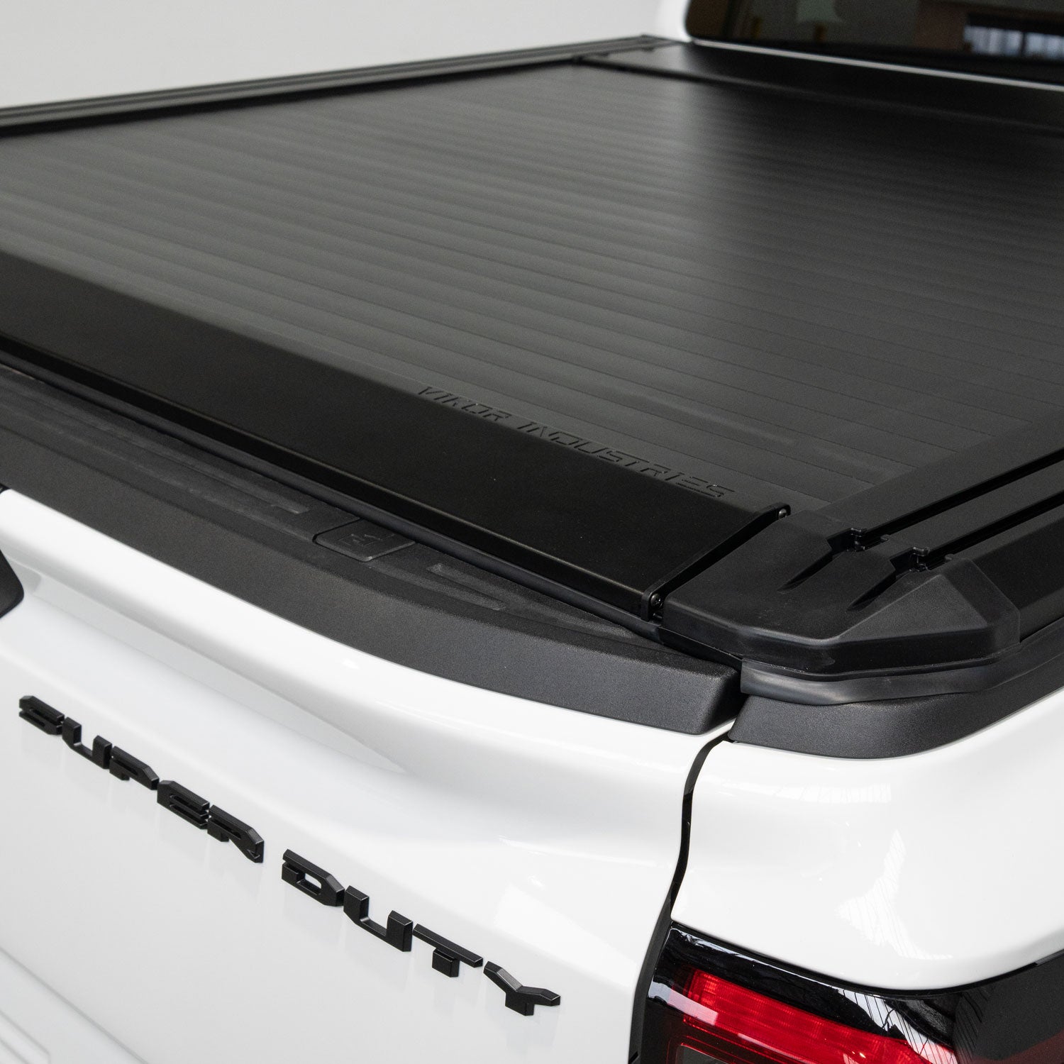 Black tonneau cover on a white Ford Super Duty truck bed