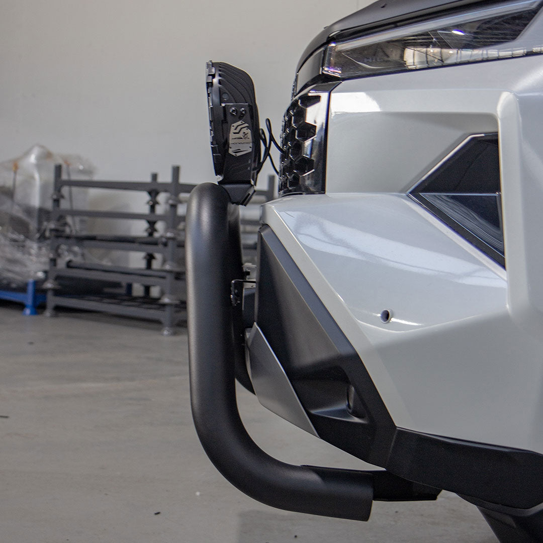 Close-up of a vehicle's front bumper and headlight in a warehouse setting