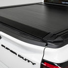 Black tonneau cover on a white Ford Super Duty truck bed