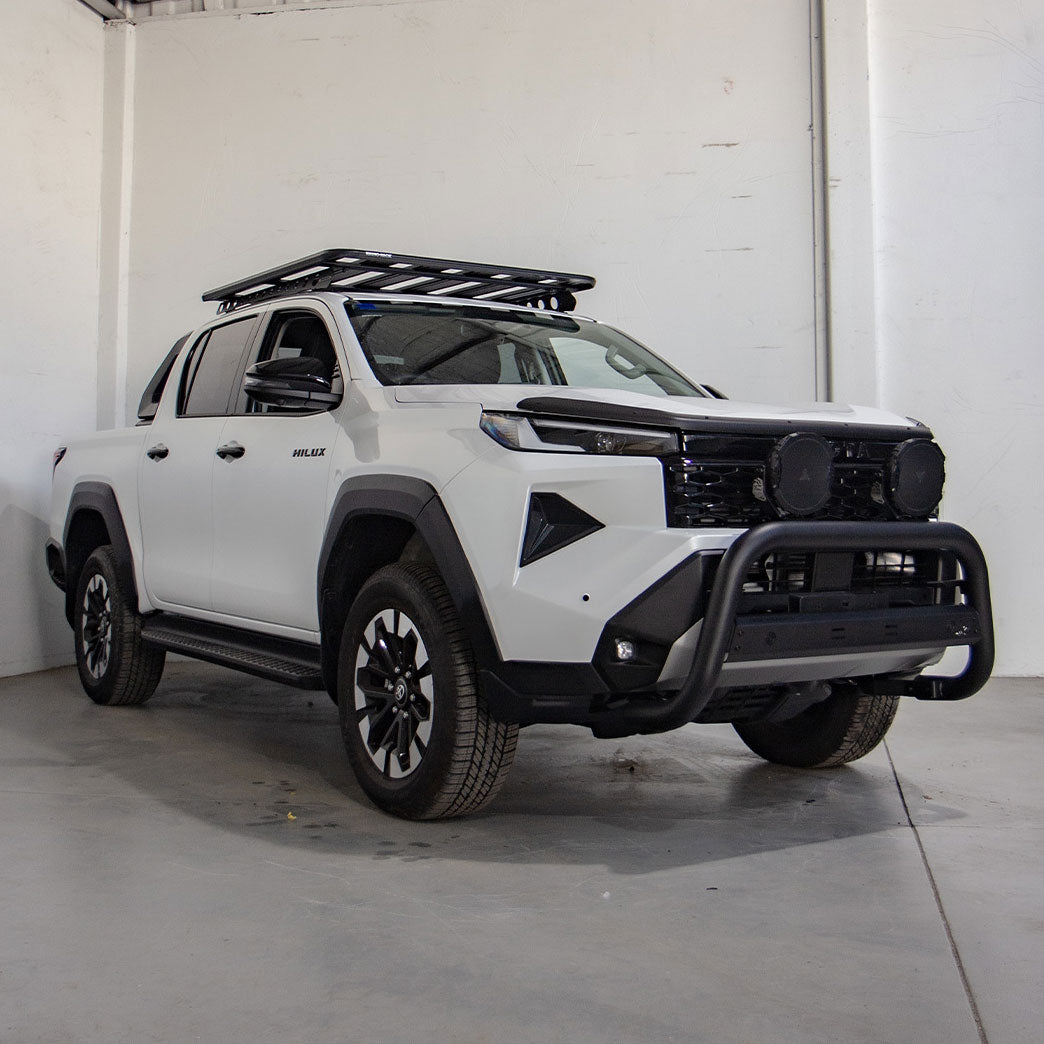 White pickup truck with black accessories in a warehouse setting