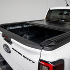 White Ford Super Duty truck with an open black tonneau cover on a white background